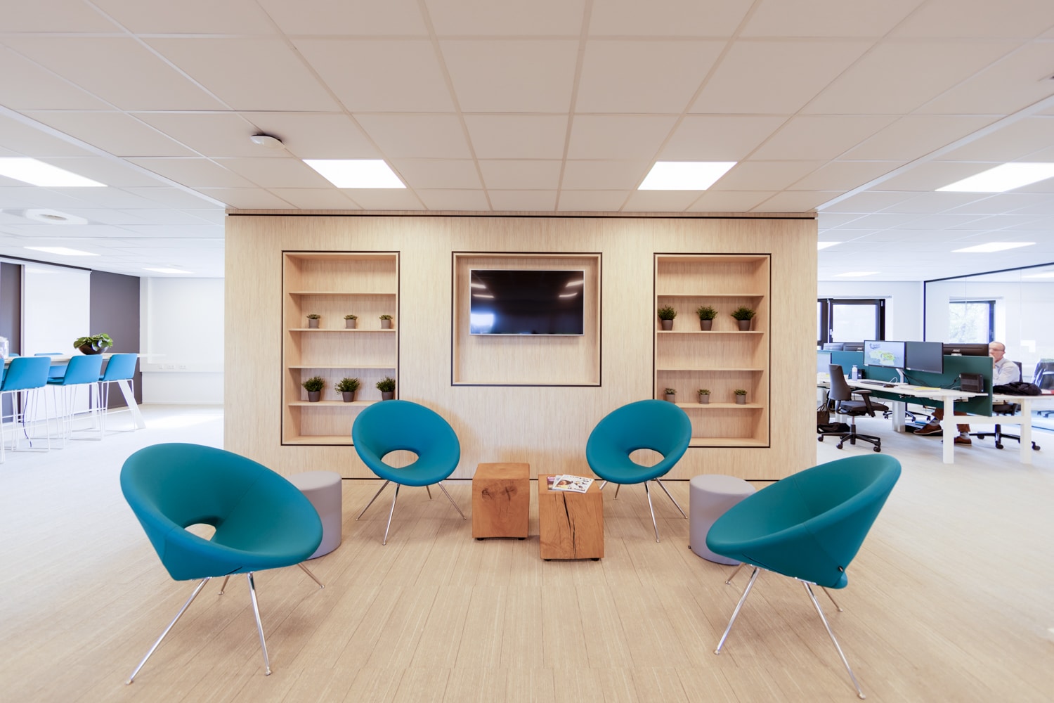 Zitruimte kantoor met blond hout plaatmateriaal en blauwe stoelen