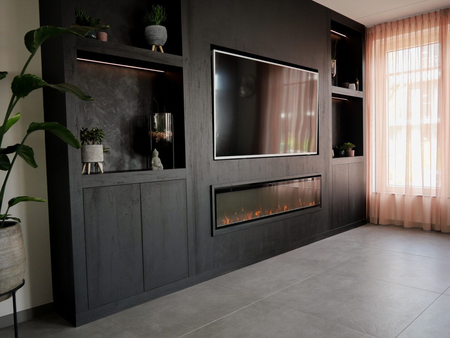 Chique cinewall met haard van plaatmateriaal met zwart houten uitstraling