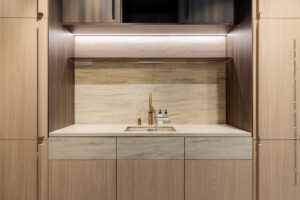 Keuken met blad en wasbak in Sahara Dune, fronten in lichte houtstructuur S173 Corteccia en bovenkasten in donkerbruin metallic decor FC98 Reflex.