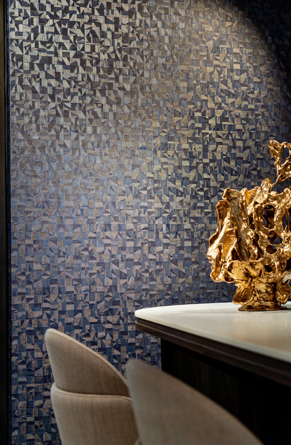 Behang Metal Textures van Casamance met blauwe tinten en daarvoor een tafel met grote gouden vaas