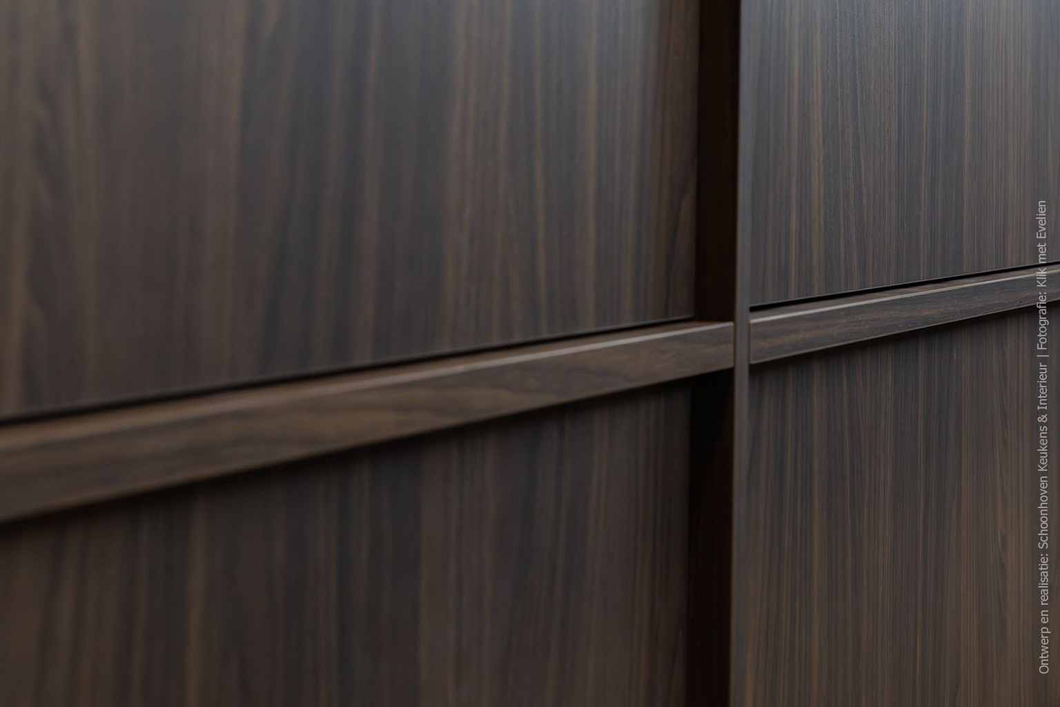 Detailfoto van kookeiland in de mat donkerbruine LS17 Poro Noce met levendige walnotenhoutstructuur.