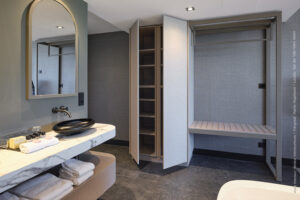 Hotelkamer met maatwerk kast in textieldecor FD32 Alpaca en een badkamermeubel uitgevoerd in de FD32 Alpaca en marmer decor FB38 Talco.