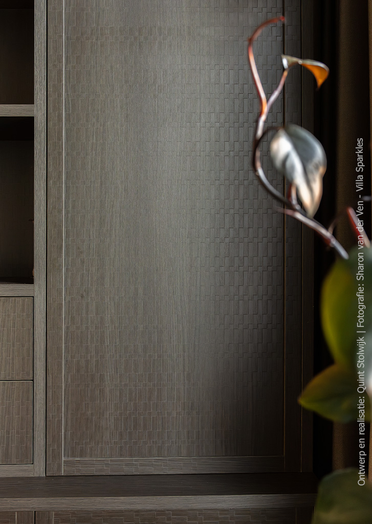 Detailfoto van een maatwerkkast uitgevoerd in het donkerbruine decor S181 Sbalzo, met een geometrische, driedimensionale houtstructuur.