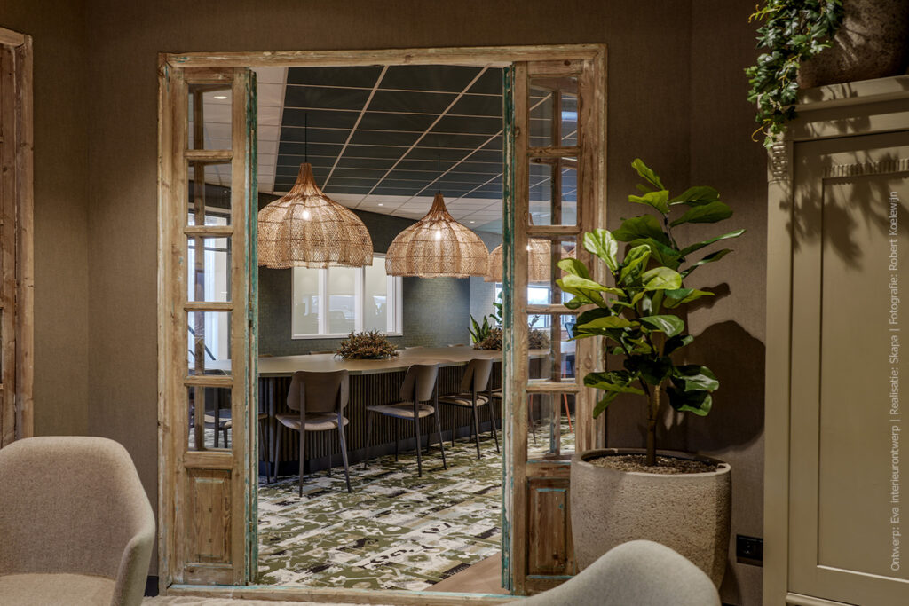 Doorkijk naar een kantoortuin met lange tafel, afgewerkt in UB54 Primofiore met een leerachtige structuur in een legergroene tint